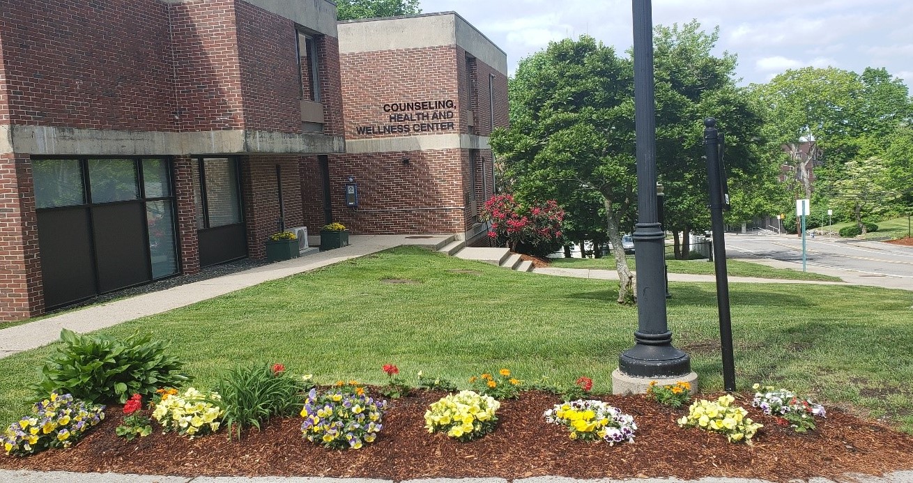 a picture of the Health Center Building with some flowers and trees