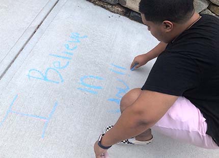 student writing with chalk