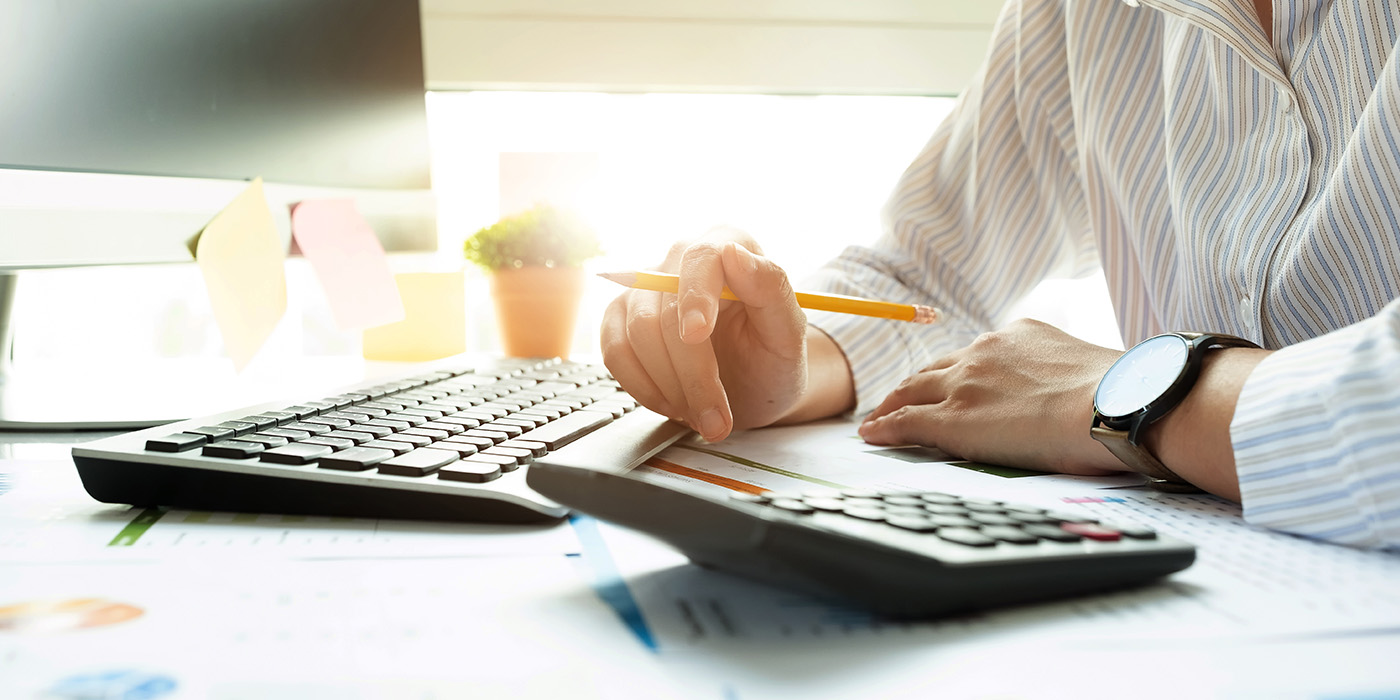 Person Sitting with Computer and Calculator in front of them
