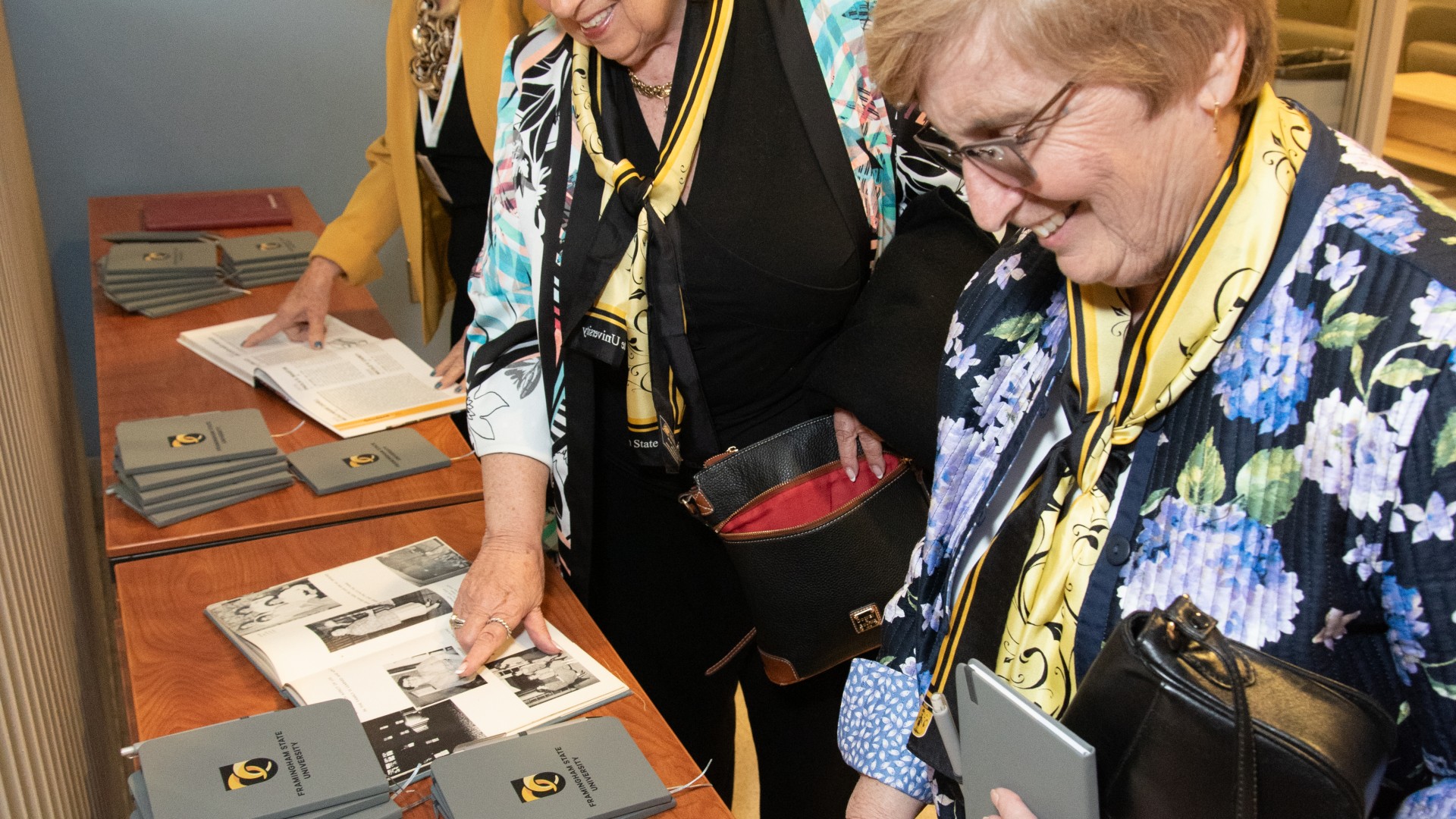Framingham State University alumni looking at old yearbooks
